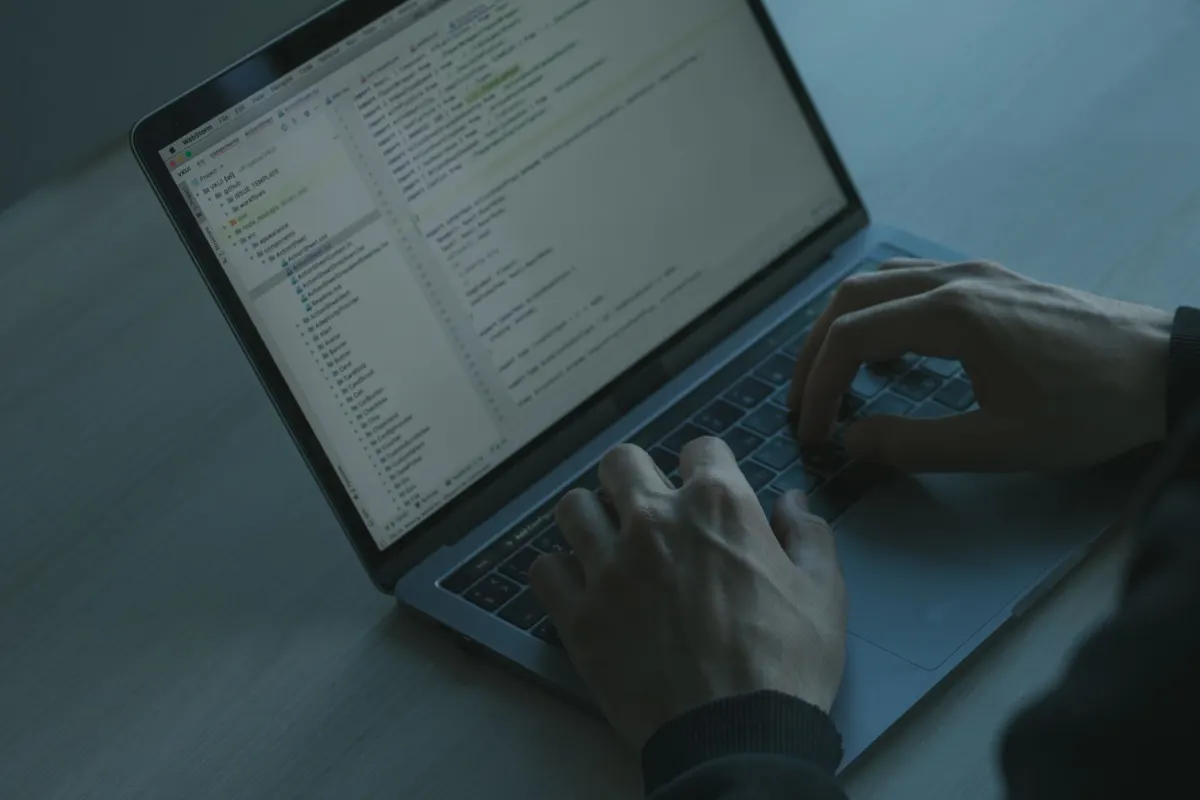 Hands typing on a laptop keyboard