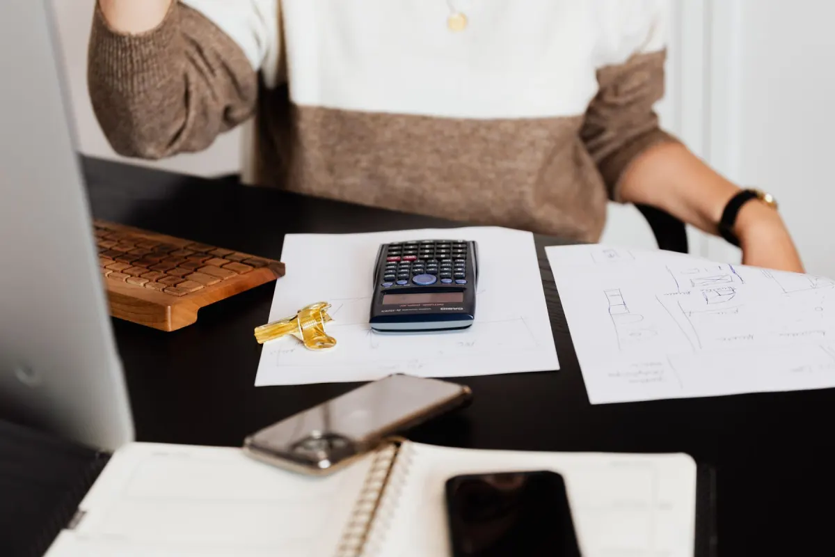Black calculator resting on printed figures: the reports and invoices that are usually automated first